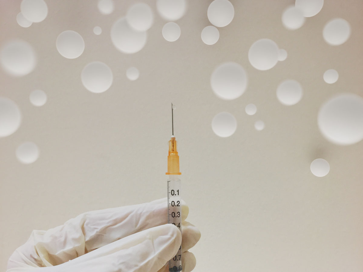 Microspheres floating above man holding syringe